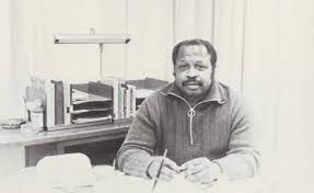 Old black and white photo of Bruce D. Nesbitt in front of desk.